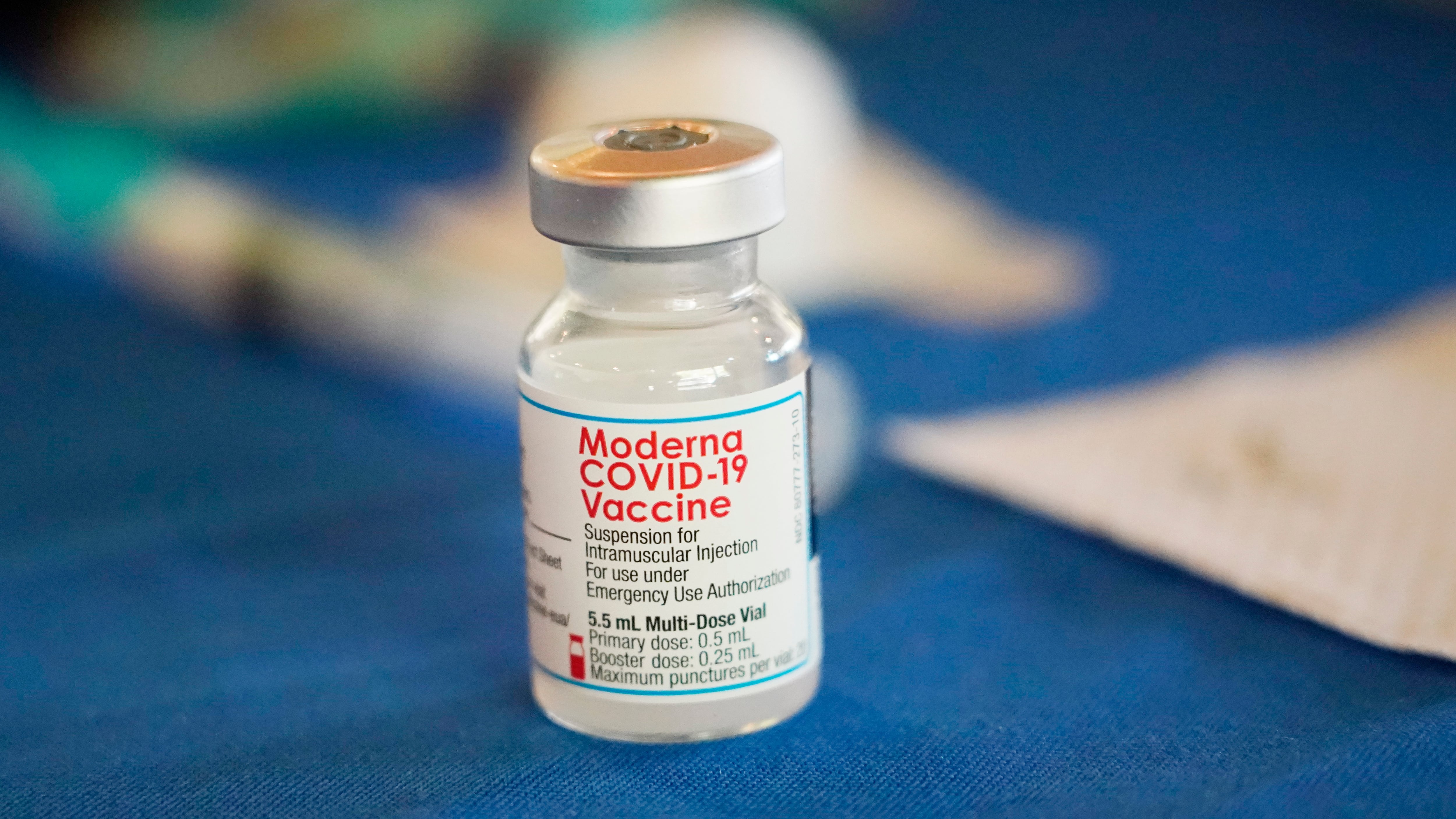 FILE - A vial of Moderna COVID-19 vaccine rests on a table at an inoculation station in...