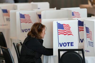 FILE - A voter fills out her ballot for the Michigan primary election in Grosse Pointe Farms,...