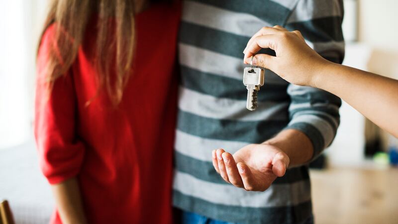 Someone hands keys to two other people.