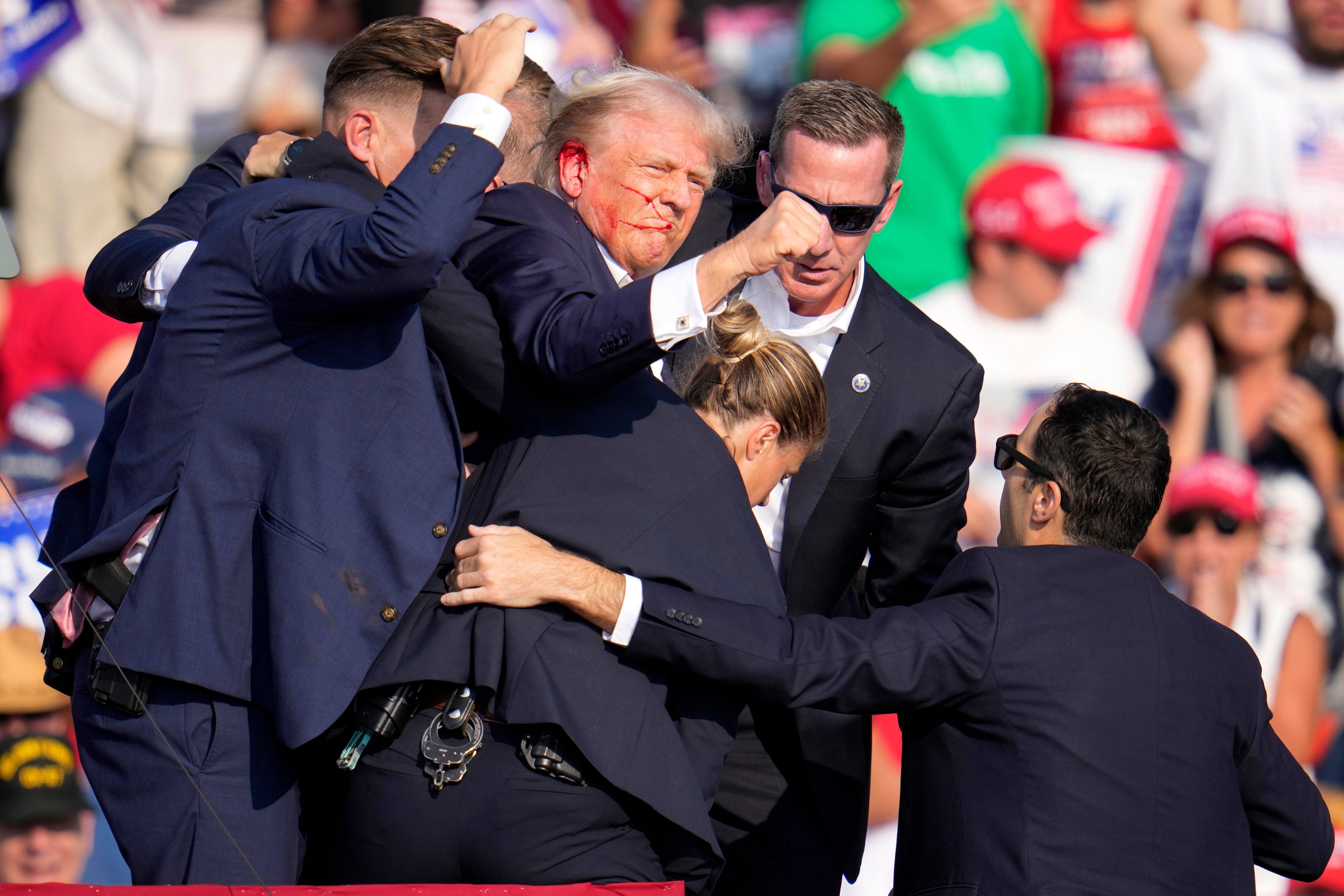 Republican presidential candidate former President Donald Trump is helped off the stage by...