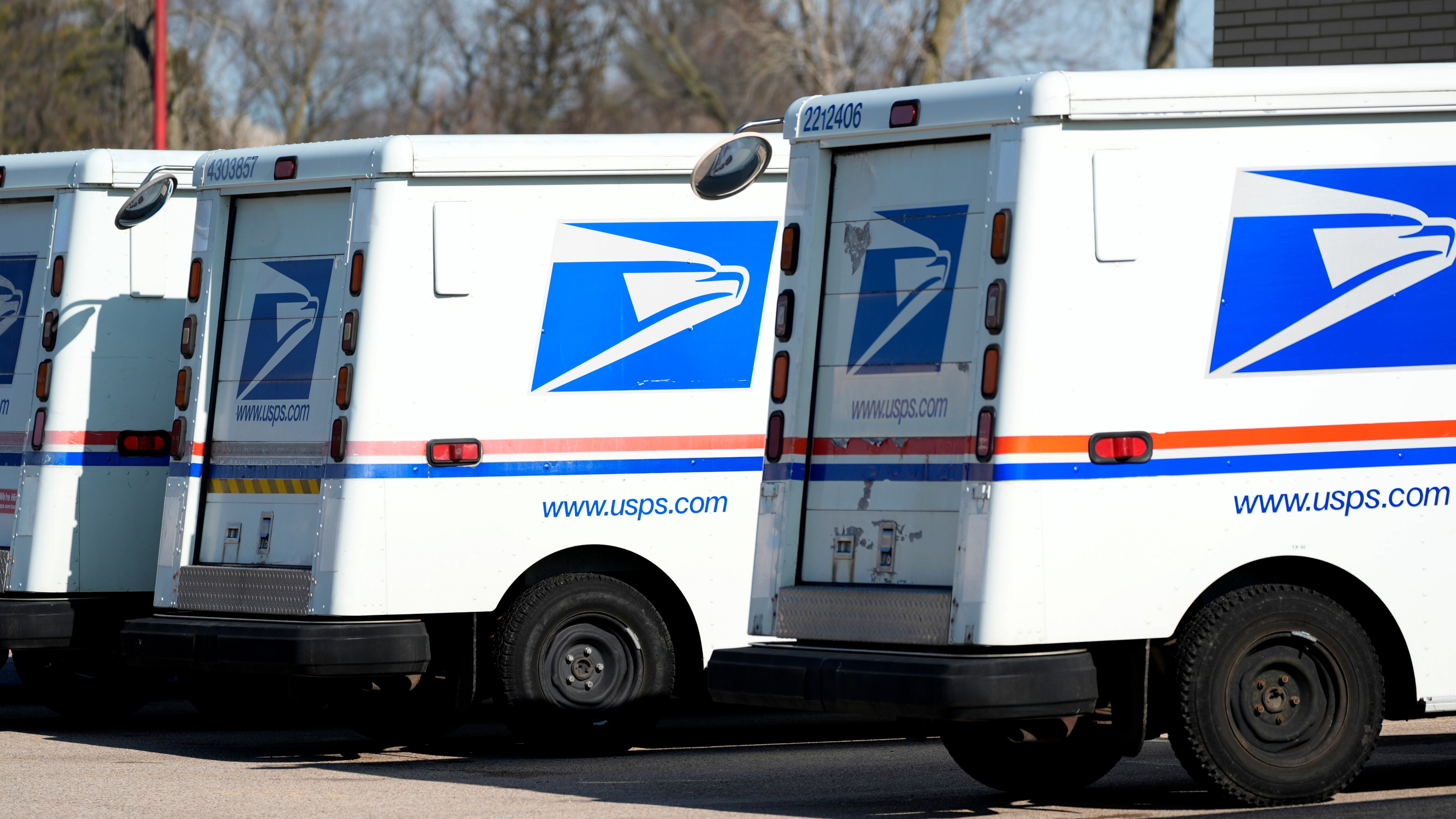 FILE - U.S. Postal Service trucks park outside a post office in Wheeling, Ill., Monday, Jan....