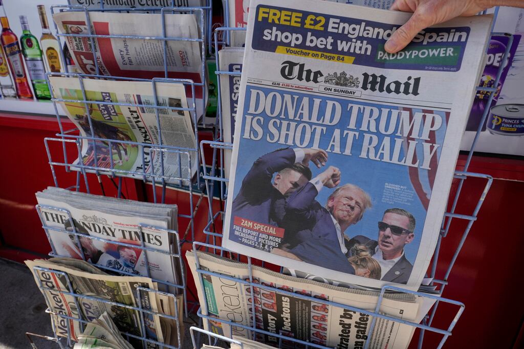 A woman buys a copy of the British Mail on Sunday newspaper at a newsagents in London, Sunday,...