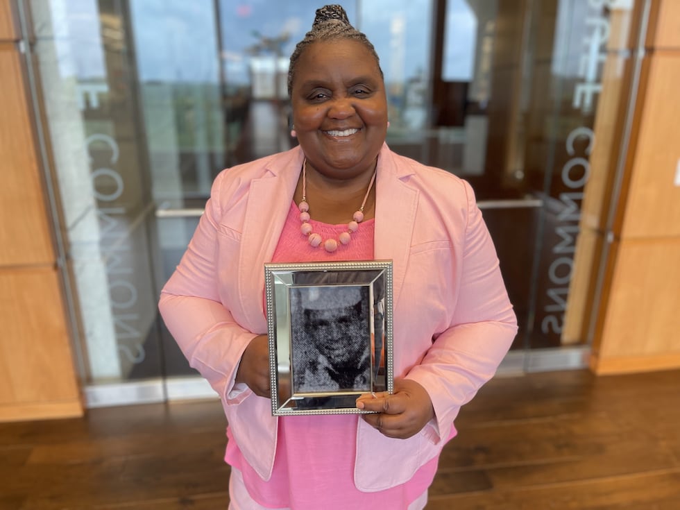 Wanda Charles poses holding a picture of her uncle, Crispin Charles, Jr. She had never seen...