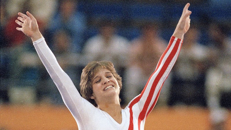 FILE - Mary Lou Retton celebrates her balance beam score at the 1984 Olympic Games, Aug. 3,...