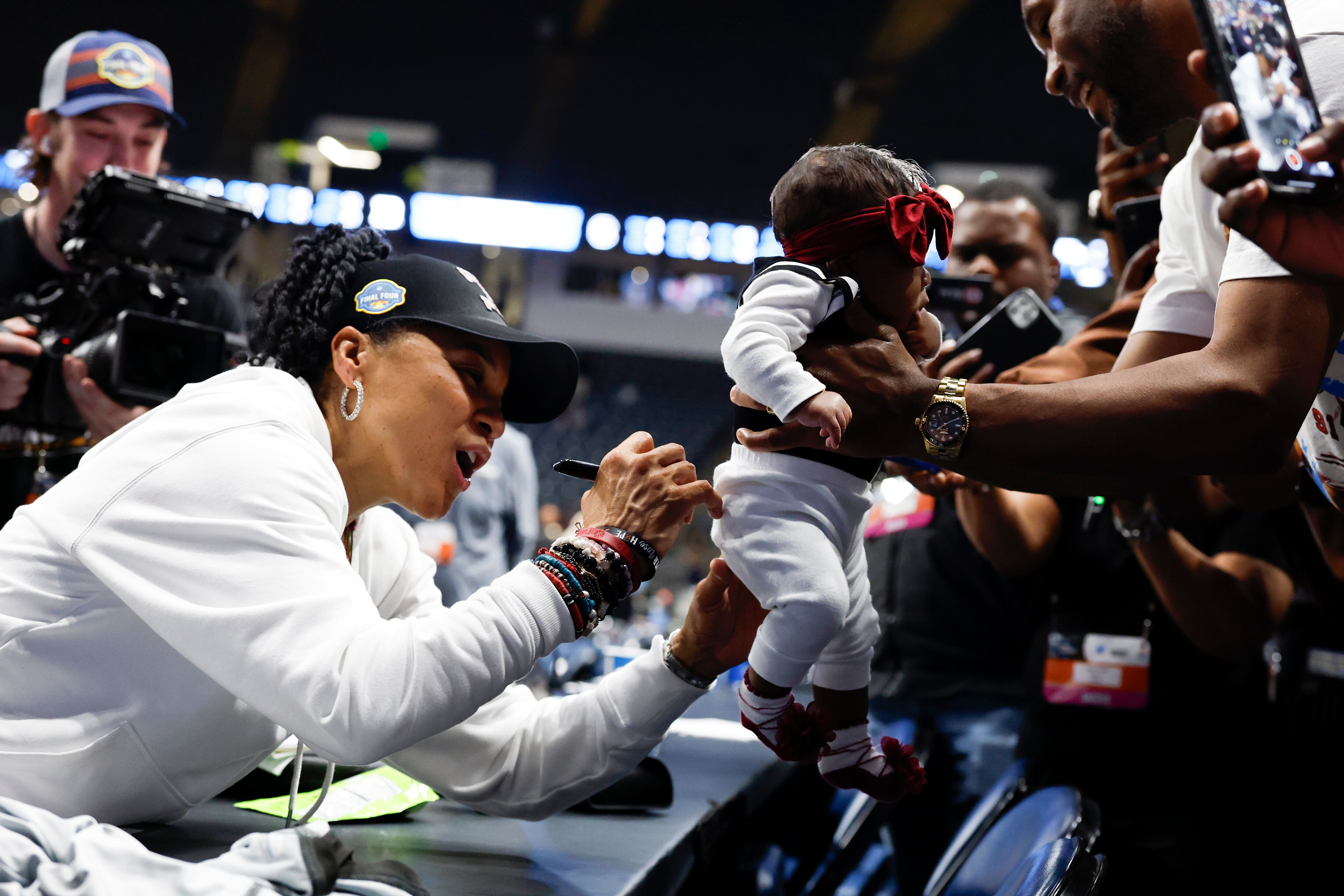 South Carolina head coach Dawn Staley autographs a baby's clothes after defeating Duke in the...