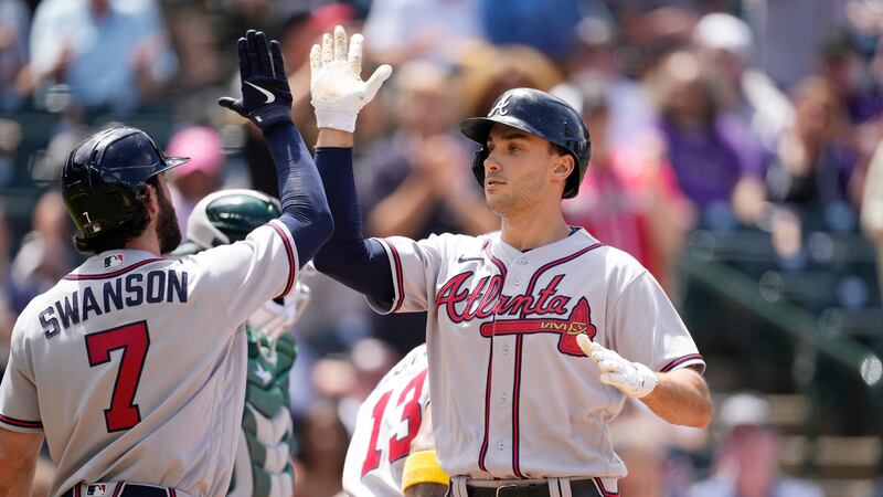 Atlanta Braves' Dansby Swanson, left, congratulates Matt Olson who crosses home plate after...