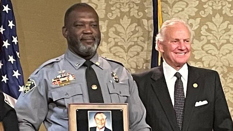 Capt. Eric Abdullah, left, is congratulated by South Carolina Gov. Henry McMaster.
