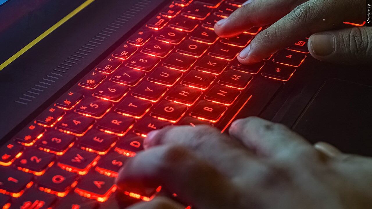 Hand typing on red keyboard