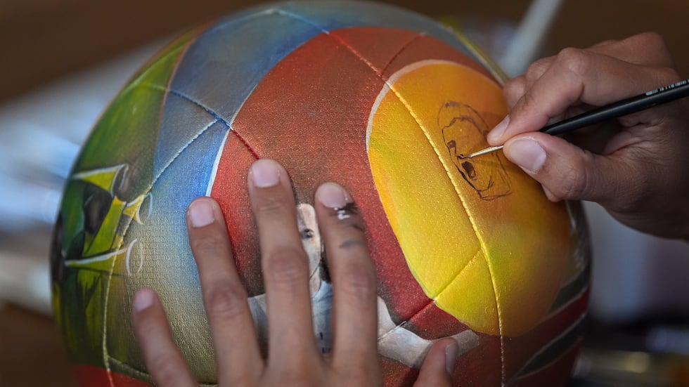 Artist Lili Cantero paints a soccer ball with images commemorating Spain's 2010 World Cup...