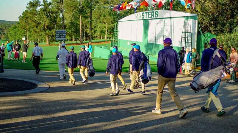 Patrons applaud as Drive, Chip and Putt competitors walk onto the course on April 3, 2022, at...