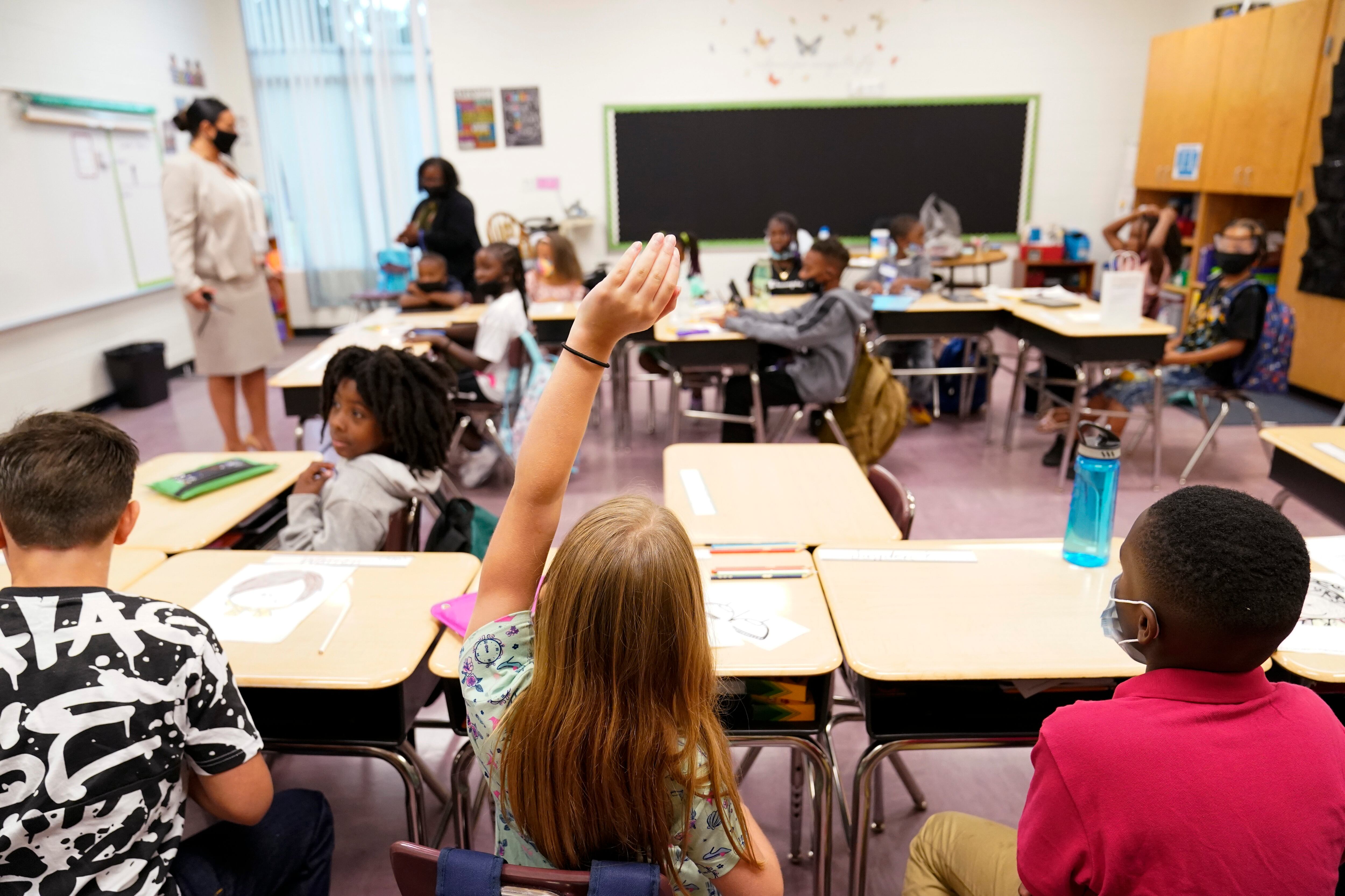 FILE - A student raises their hand in a classroom at Tussahaw Elementary school Aug. 4, 2021,...