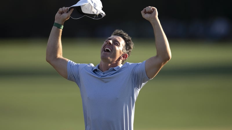 Masters champion Rory McIlroy of Northern Ireland celebrates on No. 18 with clenched fists...