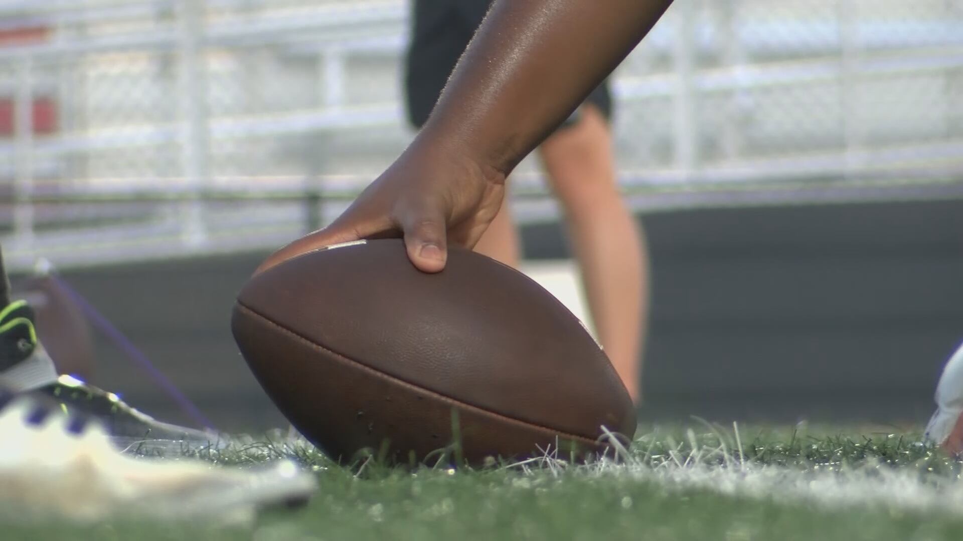 A high school football player grips a football pre-snap