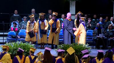 Graduates at Academy of Richmond County and Davidson Fine Arts walk across stage on Wednesday.