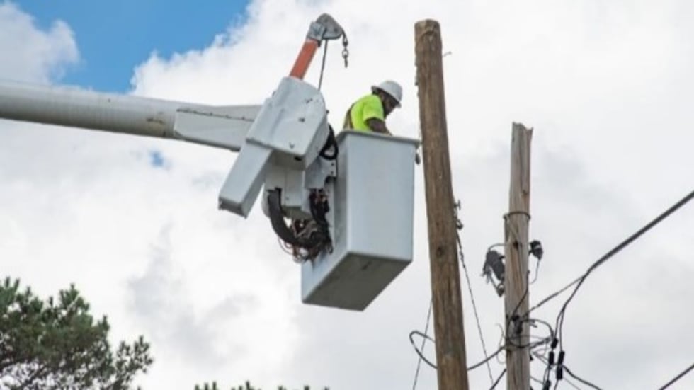 In Augusta, a utility worker repairs telephone lines after Hurricane Helene.