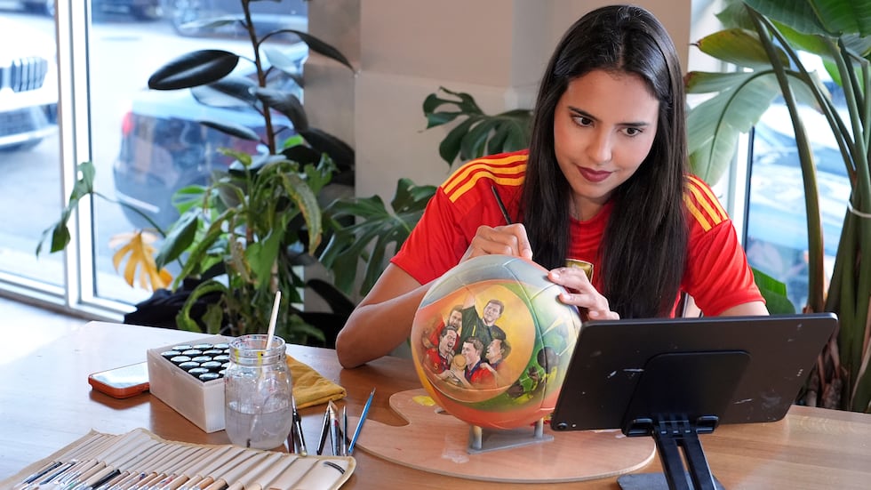 Artist Lili Cantero paints a soccer ball with images commemorating Spain's 2010 World Cup...