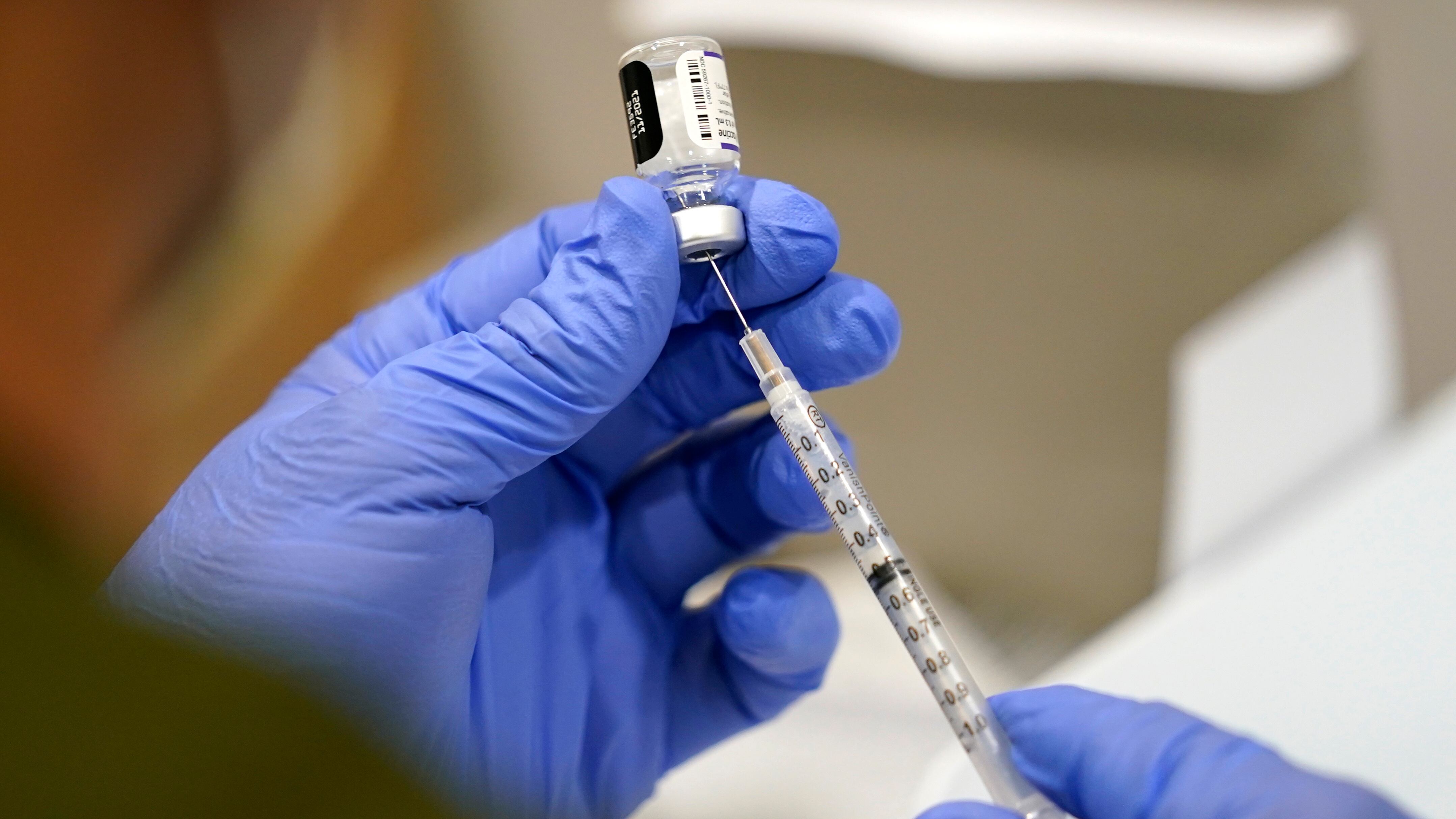 FILE - A healthcare worker fills a syringe with the Pfizer COVID-19 vaccine at Jackson...