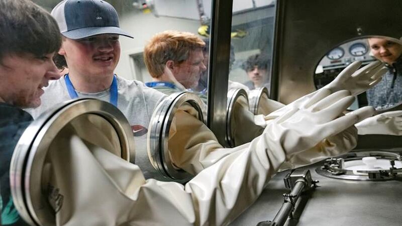 Aiken County Public School District students test out a mock glovebox during a tour of the...