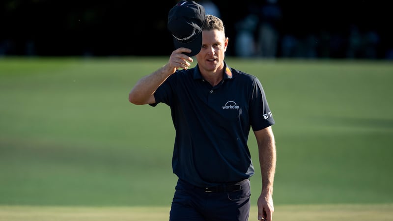 Justin Rose of England tips his hat to the patrons on the No. 18 green during the final round...