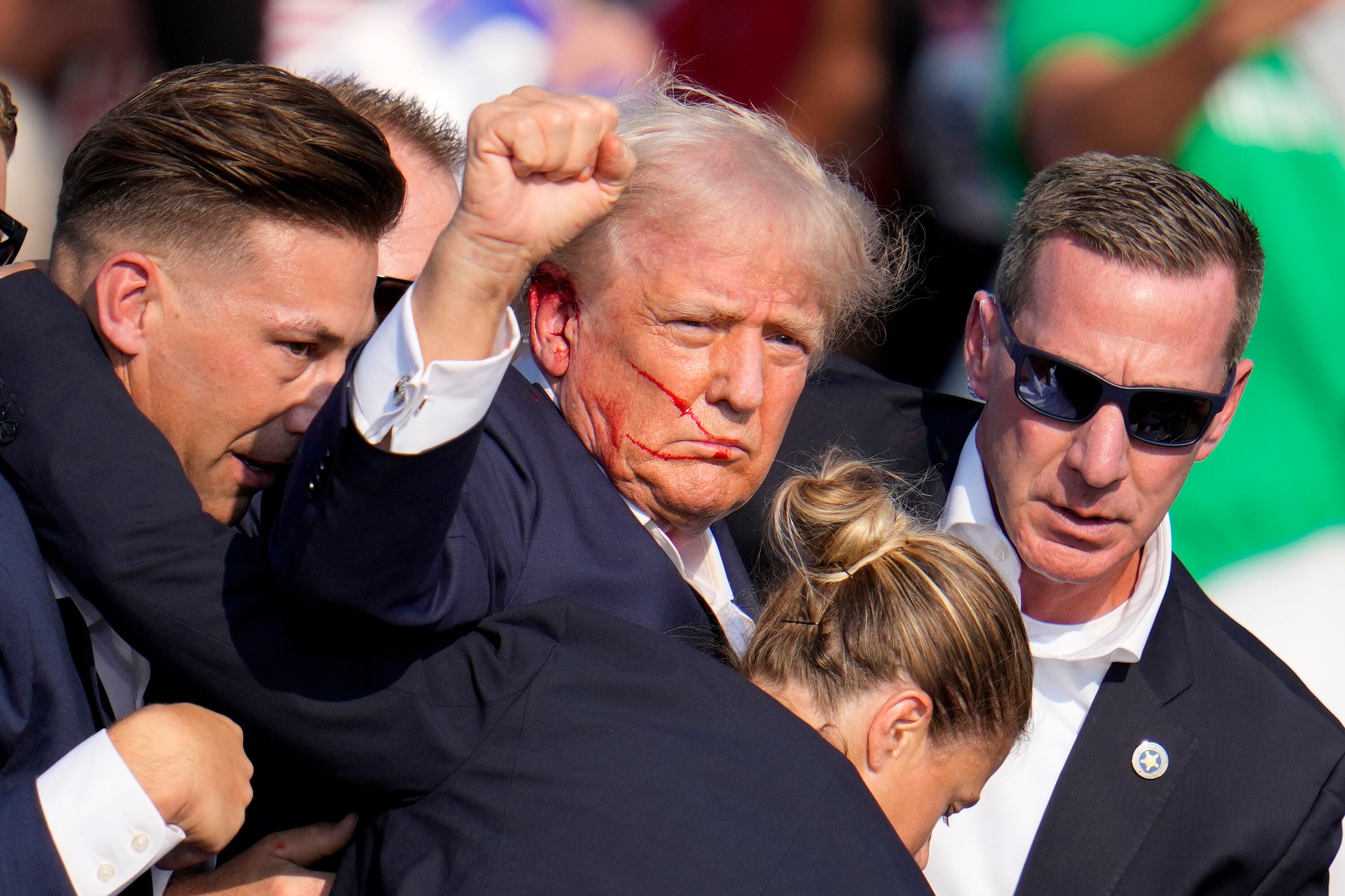 Republican presidential candidate former President Donald Trump is helped off the stage by...