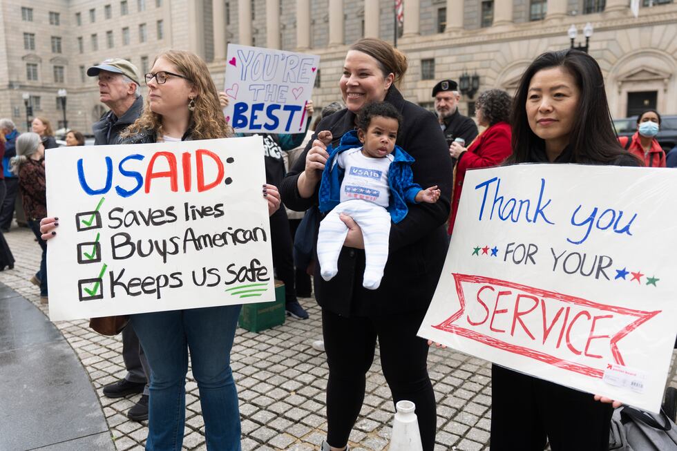 FILE - United States Agency for International Development (USAID) ers hold banners as...
