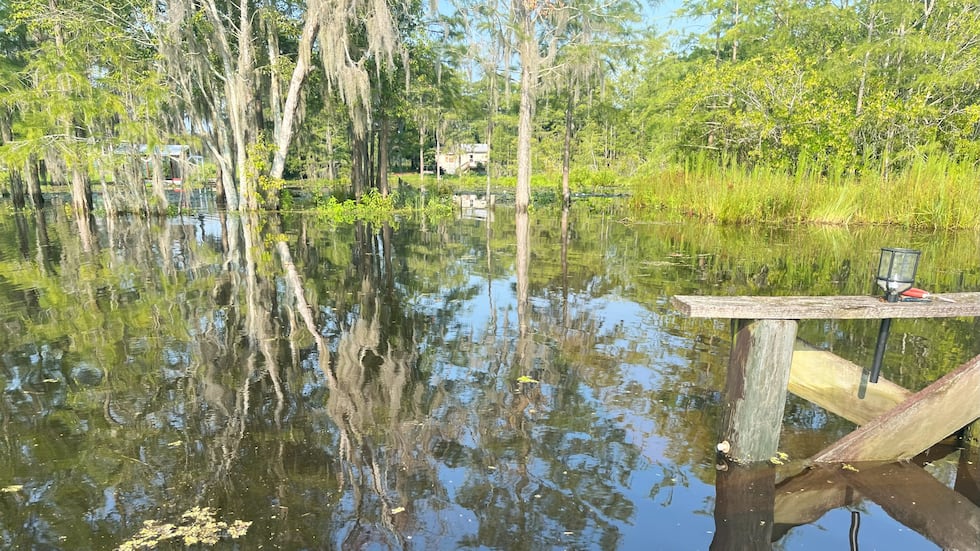 A wooden bridge is usually entirely above water at a home on Eureka Road, but after flooding,...