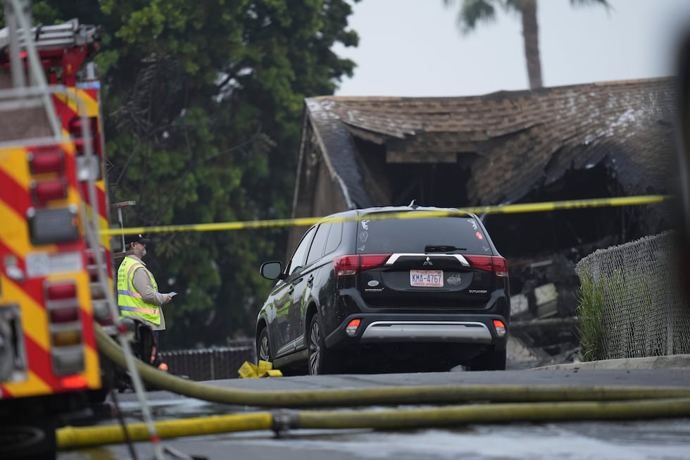 Authorities work the scene where a small plane crashed into a San Diego neighborhood, setting...