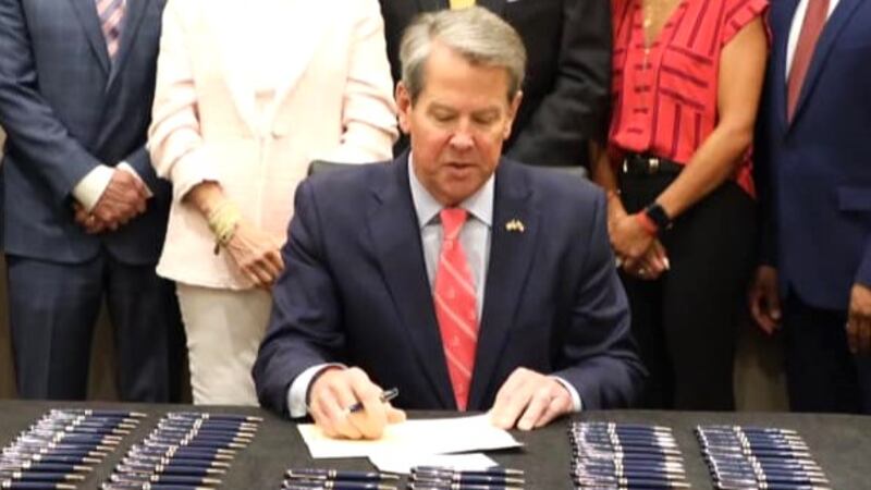 Gov. Brian Kemp signs education bills on April 13, 2023, during a superintendents' convention...