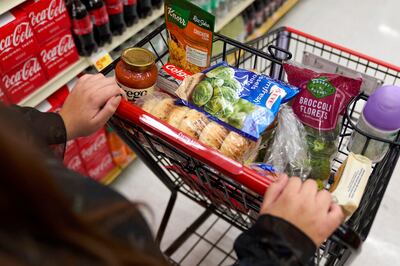Jaqueline Benitez, who depends on California's SNAP benefits to help pay for food, shops for...