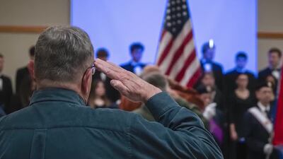 Veteran salutes flag at event.