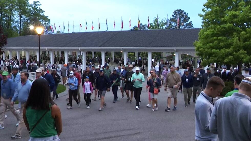 Excited patron s pour through the gate for the first day of practice rounds at Augusta...