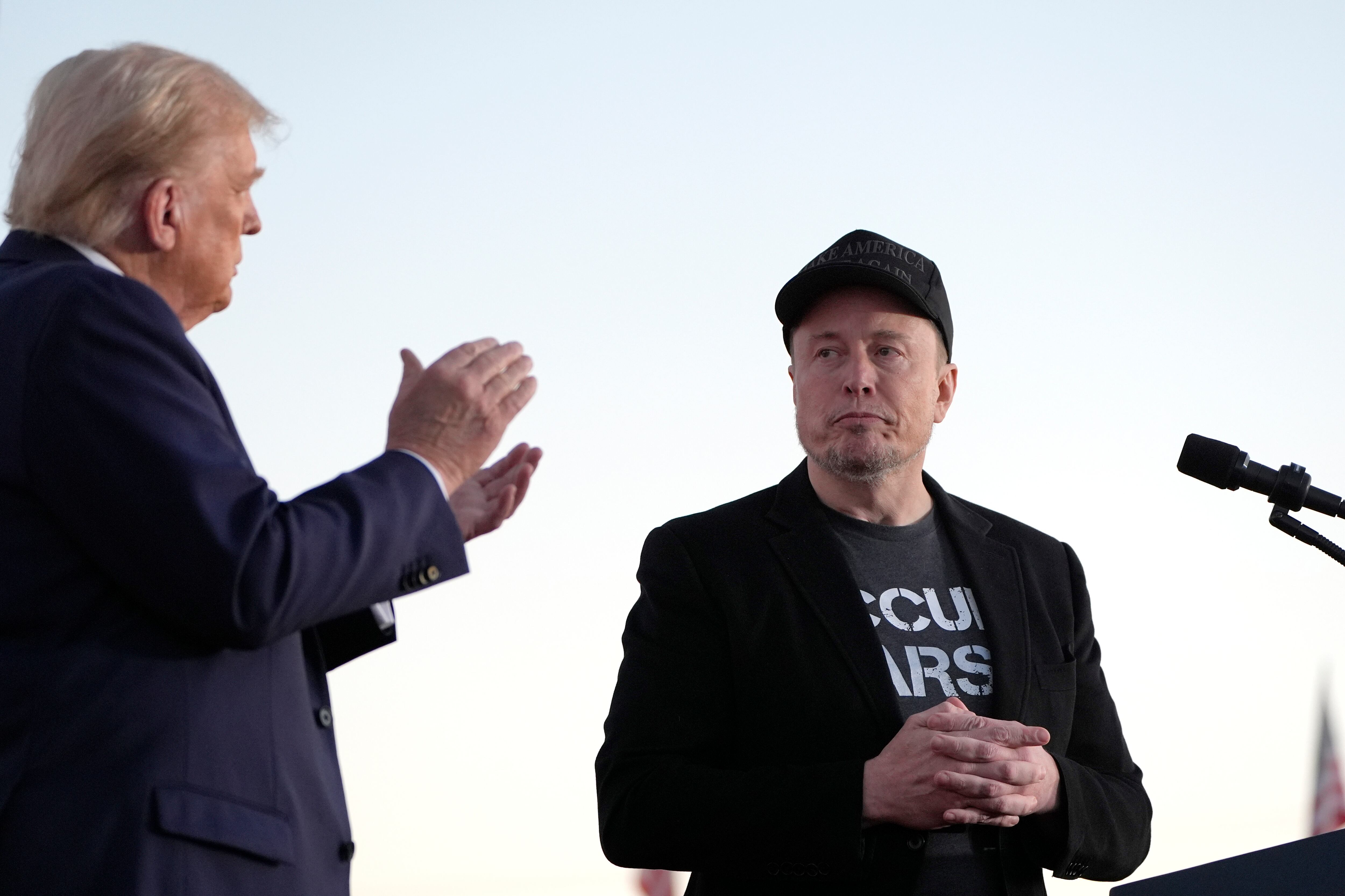 FILE - Republican presidential nominee former President Donald Trump, left, claps as Tesla and...