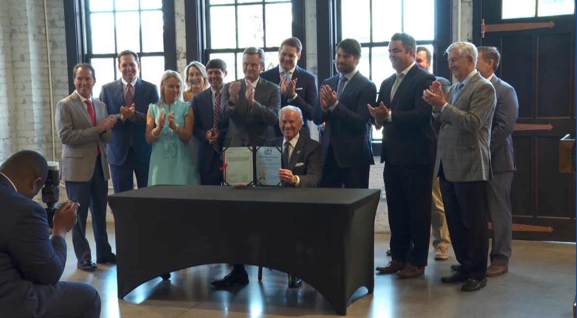 Gov. Henry McMaster holds up a new law during a bill g ceremony in West Columbia on Aug....