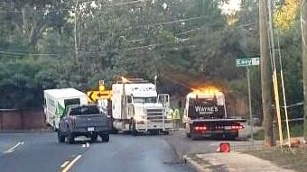 Truck crashes thru signs, Whiskey Road wall