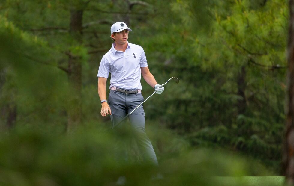 Amateur Gordon Sargent of the United States watches his stroke from the fairway of No. 14...
