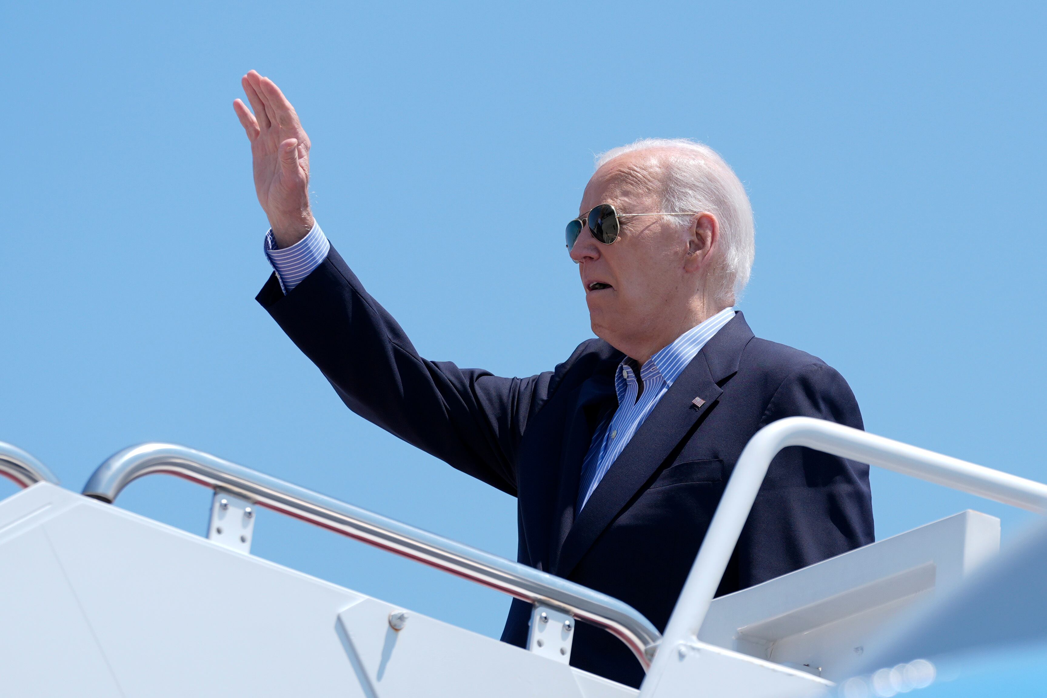 President Joe Biden waves while boarding Air Force One at Andrews Air Force Base, Md., as he...