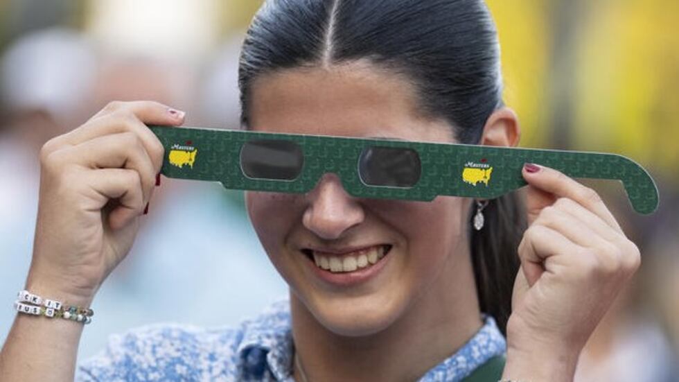 Patrons got eclipse glasses as they entered the gates at Augusta National Golf Club on April...