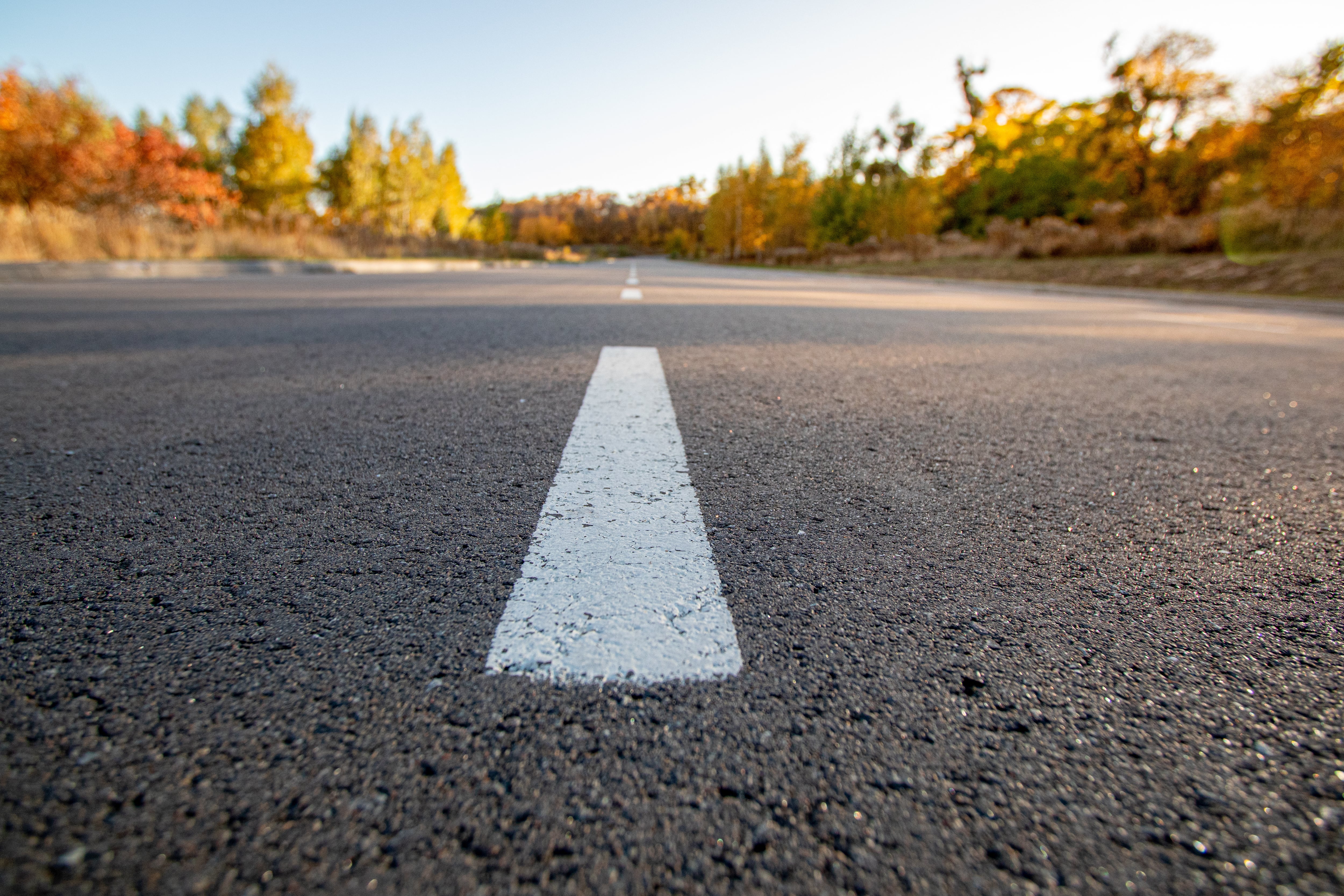 Empty gray road and the white traffic lines