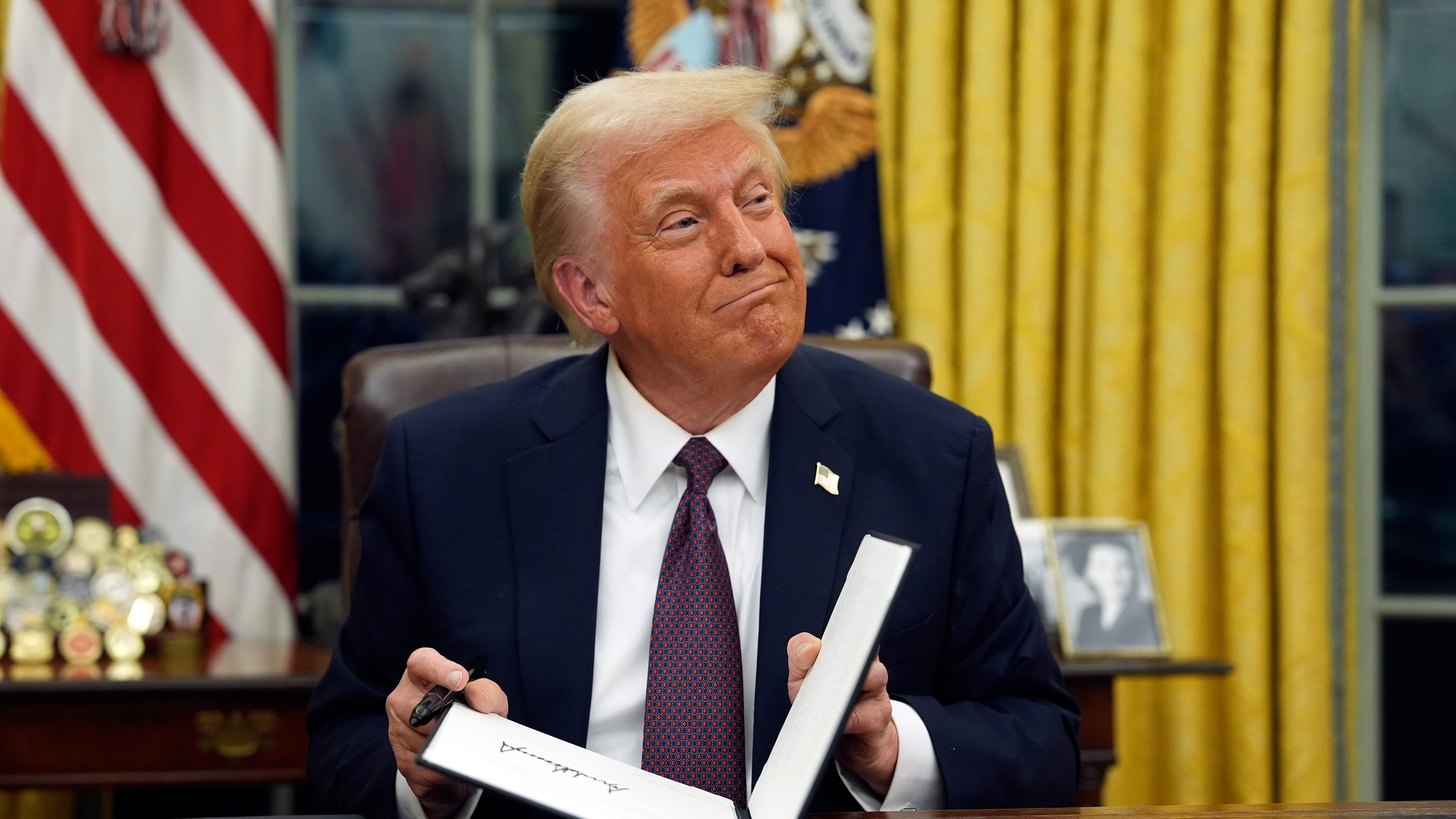 El presidente Donald Trump firma órdenes ejecutivas en la Oficina Oval en la Casa Blanca en...