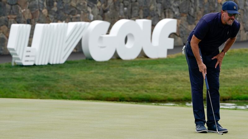 FILE - Phil Mickelson lines up a shot on the 18th hole during the first round of the...