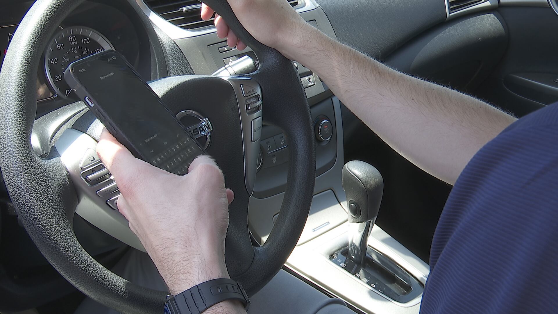 A person using their phone while driving.