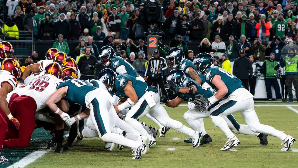 FILE - Philadelphia Eagles quarterback Jalen Hurts, center, and teammates run the tush push...