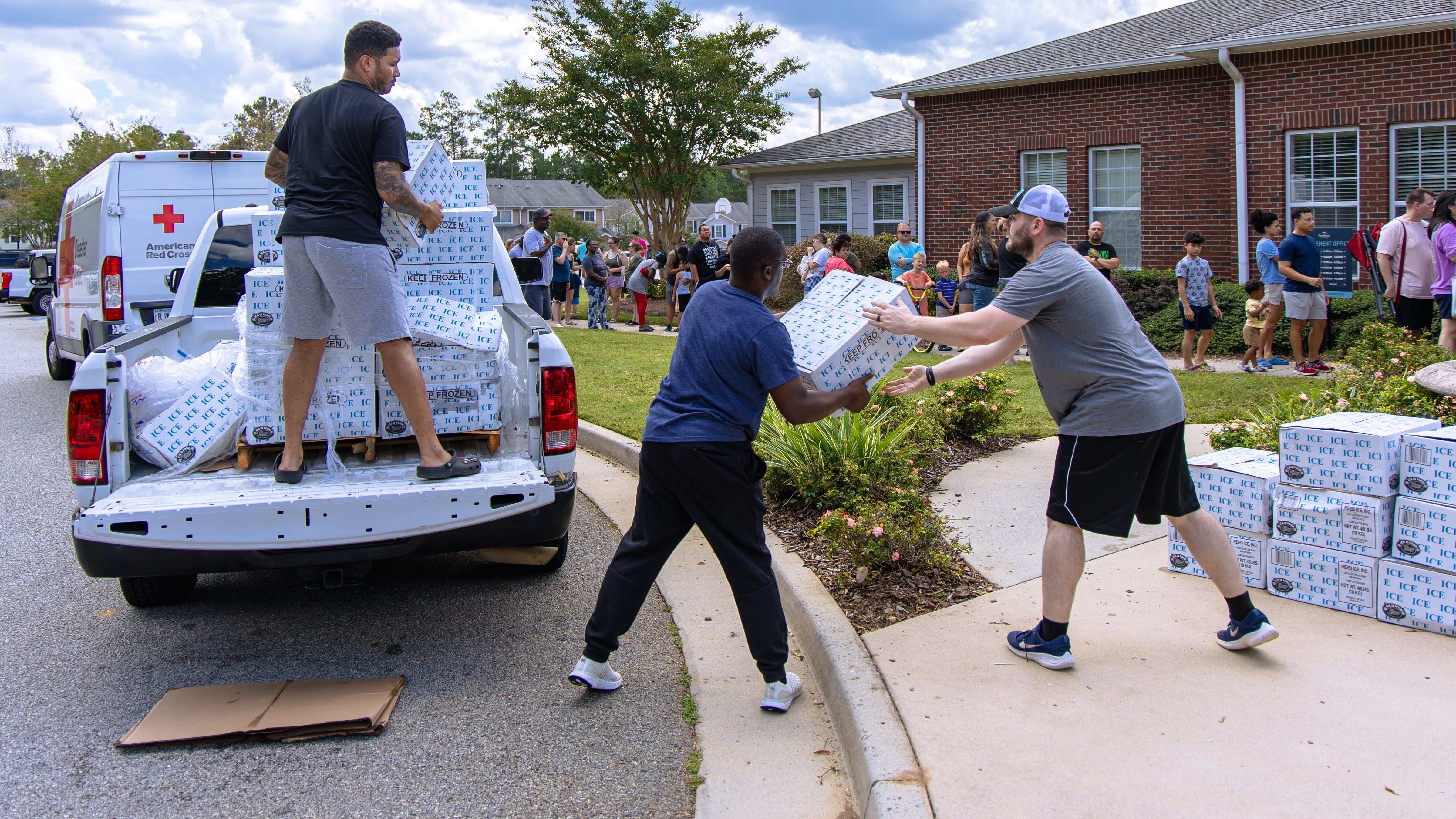 work together to unload a truck load of supplies to families healing from...