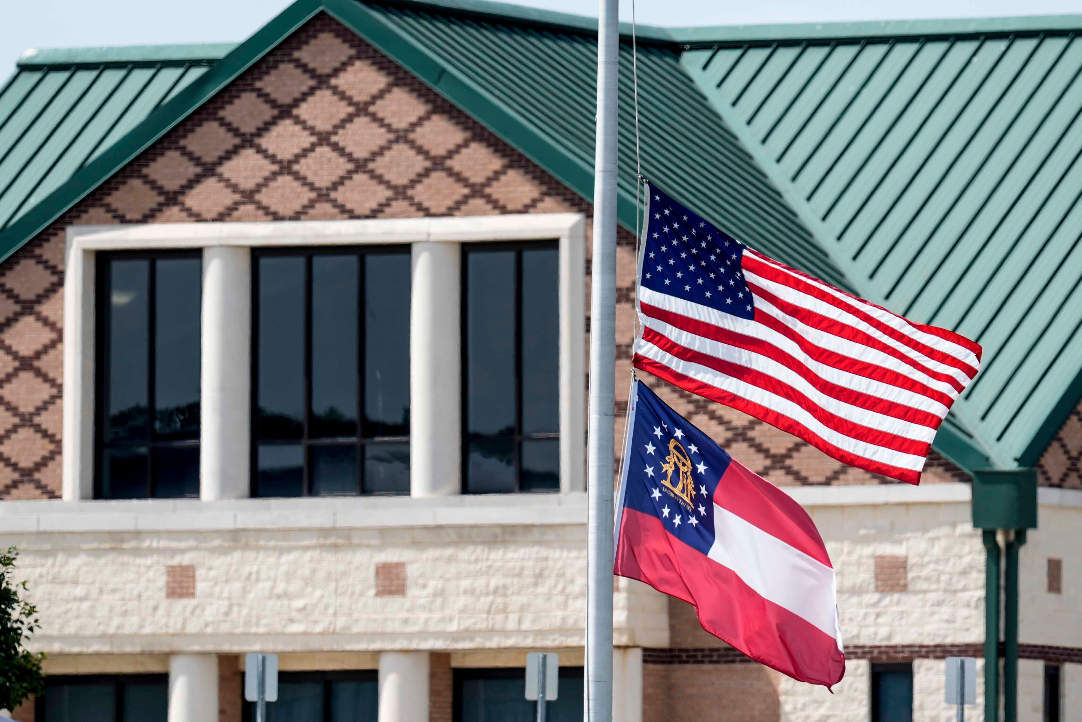 The American and state of Georgia flags fly half-staff after a shooting Wednesday at Apalachee...