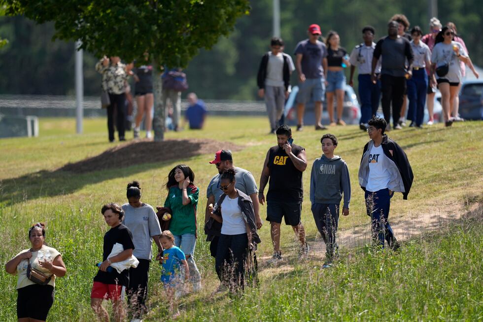 Students and parents walk off campus at Apalachee High School, Wednesday, Sept. 4, 2024, in...