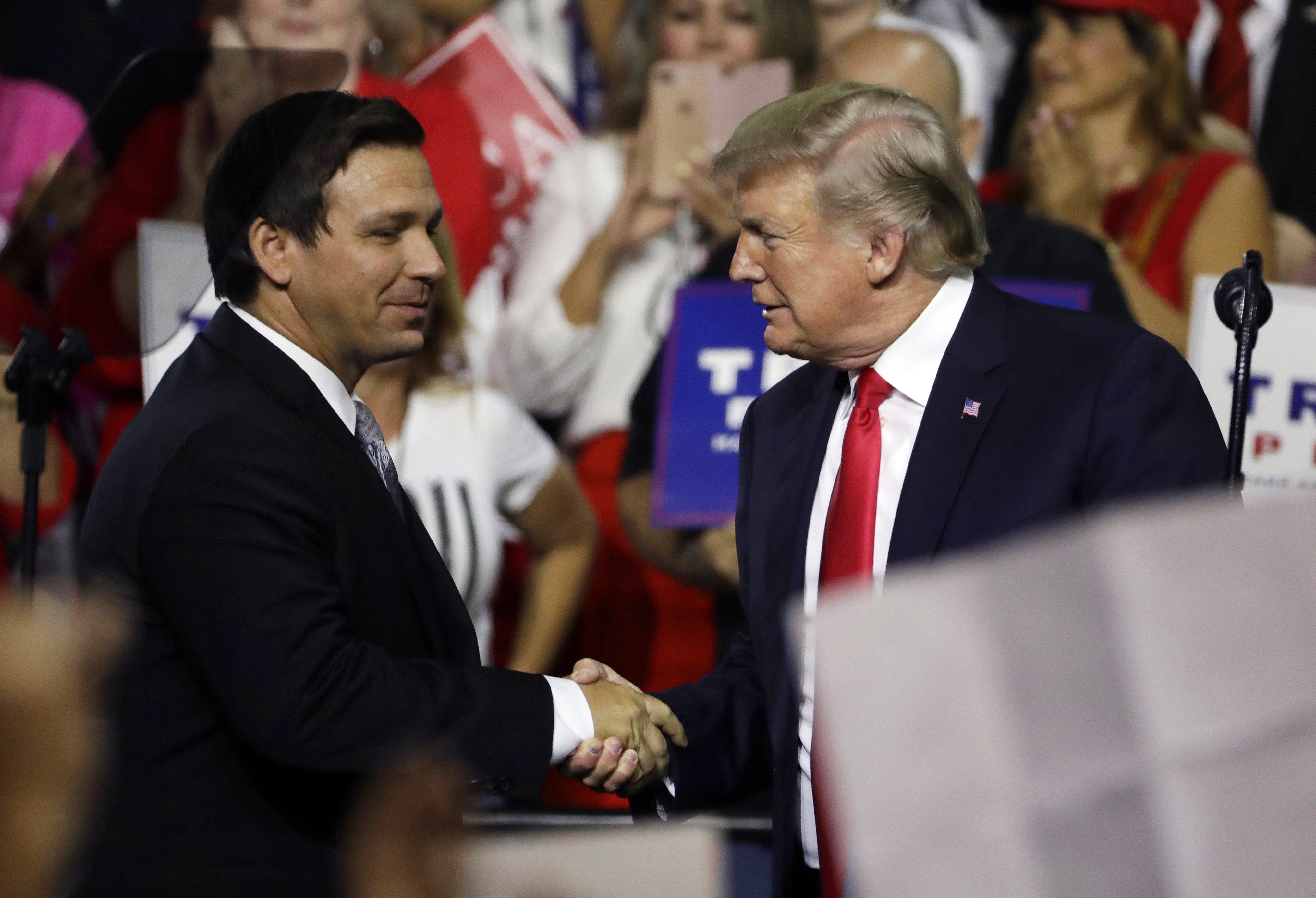 FILE - In this July 31, 2018, file photo, President Donald Trump, right, shakes hands with...