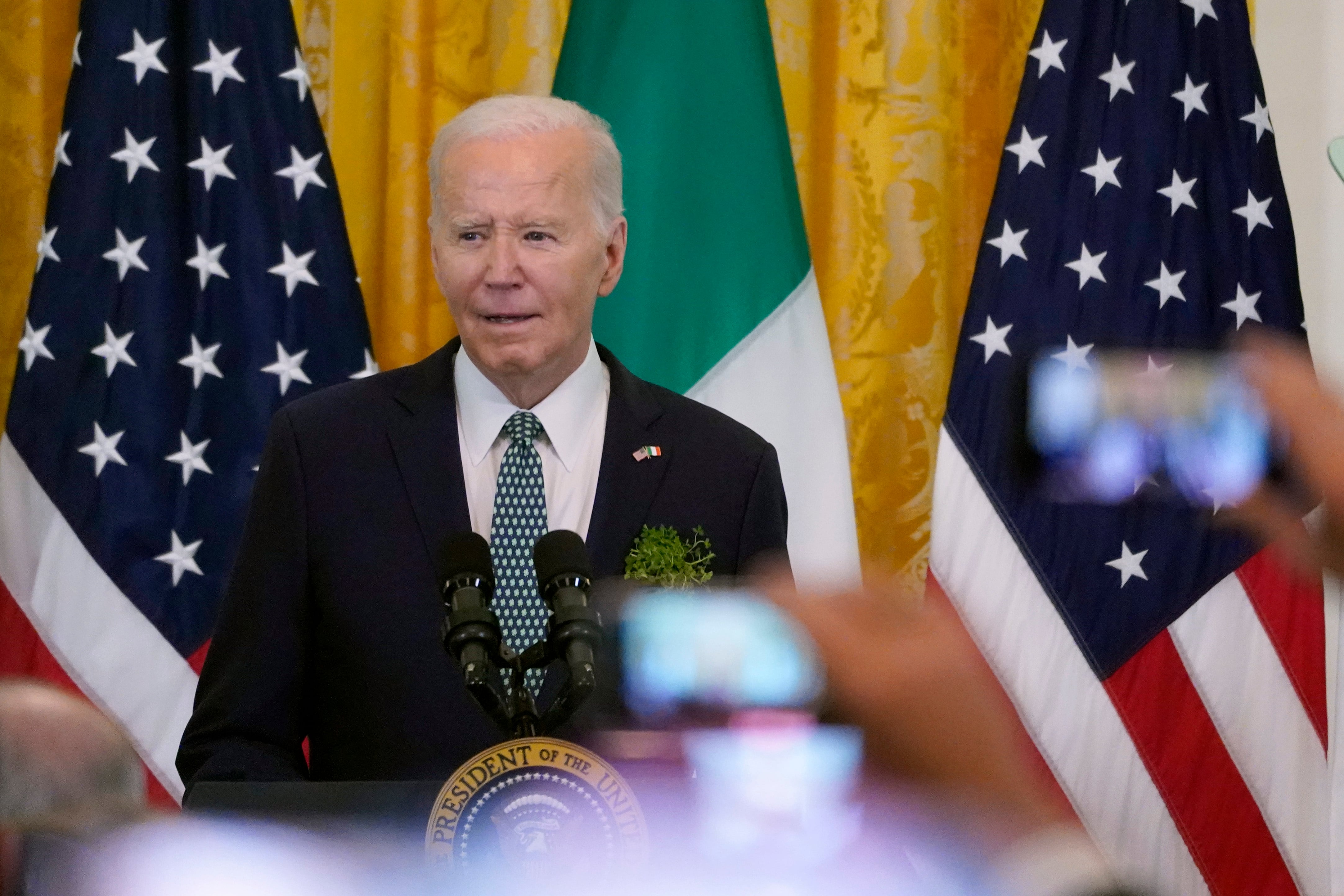 President Joe Biden speaks during a St. Patrick's Day reception in the East Room of the White...