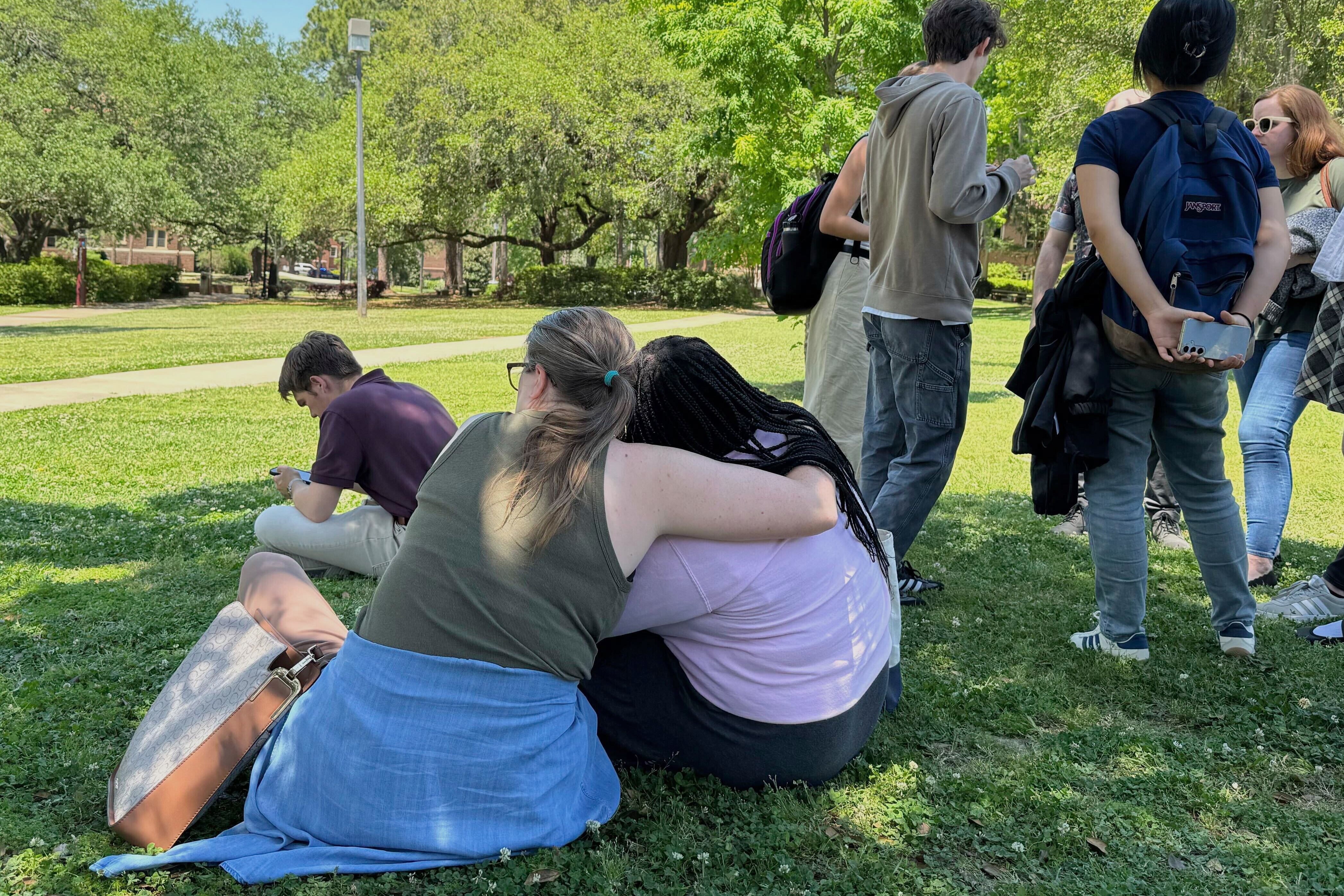 People comfort each other on Florida State University’s campus in Tallahassee, where law...